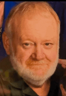 a close up of a man 's face with a beard .