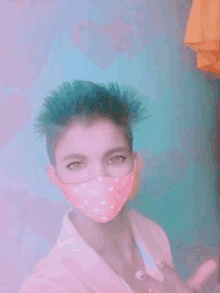 a girl with blue hair is wearing a pink face mask .