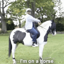 a man riding a black and white horse with the words " i 'm on a horse " on the bottom