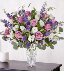 a vase filled with purple and white flowers