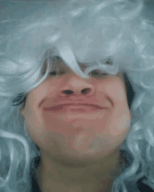 a man wearing a white wig makes a face