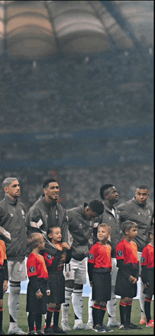 a group of soccer players standing on a field with children