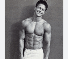 a shirtless man in calvin klein underwear smiles for the camera