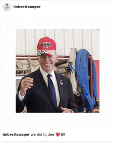 a man in a suit and tie is wearing a trump hat