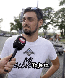 a man wearing a t-shirt that says " mi slove to je to "