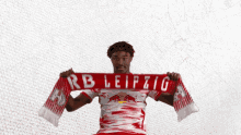 a man holding a scarf with rb leipzig written on it