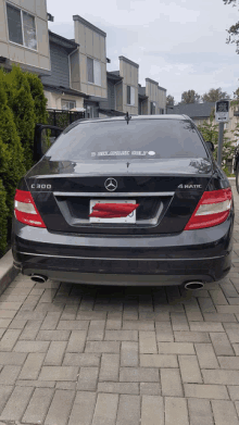 a black mercedes is parked in a parking lot