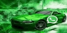 a green sports car with a whatsapp logo on the side is driving down a street .