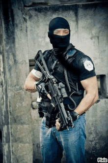 a man wearing a mask and holding a rifle .