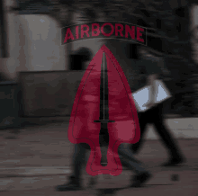 a blurred image of people walking with an airborne logo in the background