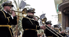 a group of men are playing trombones in a marching band