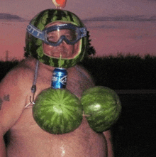 a man wearing a watermelon helmet and goggles has a can of bud light hanging from his neck