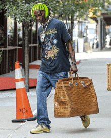 a man wearing a t-shirt that says ' always hungry ' is carrying a large bag