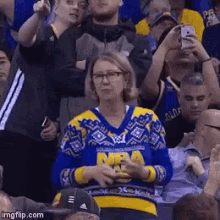 a woman wearing a blue and yellow sweater with nba on it