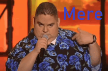 a man in a floral shirt is singing into a microphone and the word mere is behind him