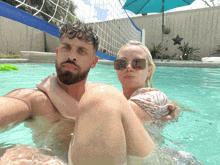 a man and a woman are in a pool with a volleyball net in the background