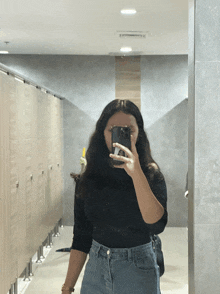 a woman taking a selfie in a public restroom