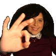 a woman is making an ok sign with her hands .