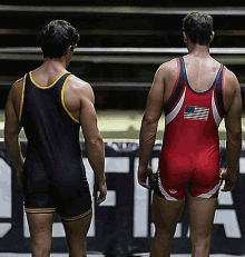 two wrestlers are standing next to each other with one wearing a red singlet with the american flag on it