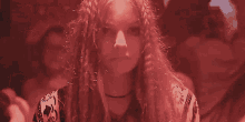 a woman with long hair is standing in a dark room with a red light behind her