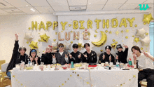 a group of young men are posing for a photo in front of a wall that says happy birthday lune