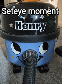 a henry vacuum cleaner is sitting on a grey carpet