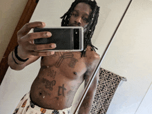 a man taking a picture of himself in a mirror with a tattoo on his chest that says poo