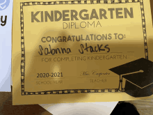 a yellow kindergarten diploma that says congratulations to sabrina stacks for completing kindergarten