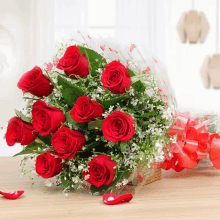 a bouquet of red roses with baby 's breath wrapped in plastic