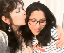 a woman kissing another woman on the cheek