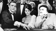 a man in a tuxedo is holding a stack of cards in front of a woman