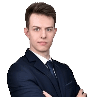 a young man in a suit and tie stands with his arms crossed