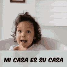 a little girl is sitting in a bathtub with the words mi casa es su casa written below her