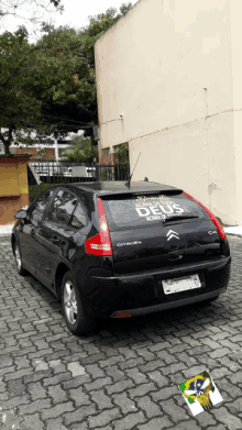 a black citroen c4 is parked on a brick pavement