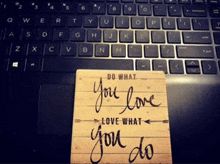 a sign that says do what you love love what you do sits on a laptop keyboard