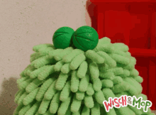 a green wisch & mop with a red background