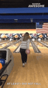 a woman is throwing a bowling ball in a bowling alley and the caption at least i did not fall