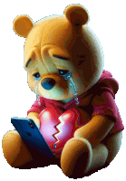 a teddy bear is crying while holding a broken heart