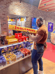 a man is holding a large toblerone bar