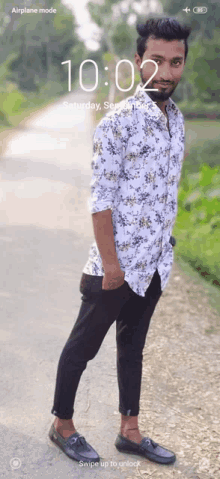 a man in a floral shirt is standing in front of a screen that says airplane mode