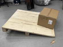 a cardboard box with the letters hf s on it sits on a wooden pallet