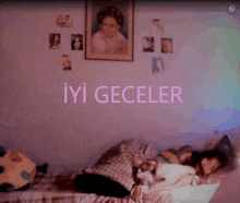 a girl is laying on a bed with the words iyi geceler written in pink