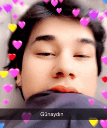 a close up of a person 's face with hearts around it and the word günaydin on the bottom