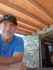 a man stands in front of a sign that says welcome to the gulf