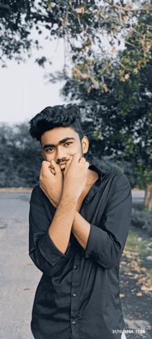 a young man in a black shirt is posing for a picture on 31/10/2021 17:28