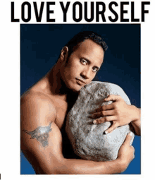 a shirtless man with a tattoo on his arm is holding a large rock in his hands .