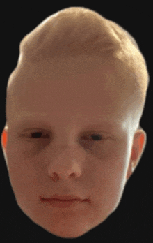 a close up of a young boy 's face with a black background