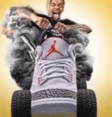 a man is driving a lawn mower made out of a pair of jordan shoes .