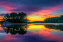 a sunset over a lake with a small island in the middle