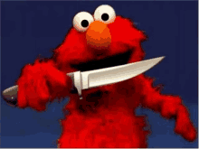 elmo from sesame street is holding a large knife in his mouth .